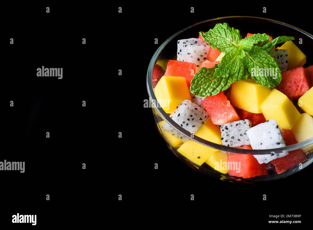 Fruit salad made of east asian fruits isolated on black background side view Stock Photo