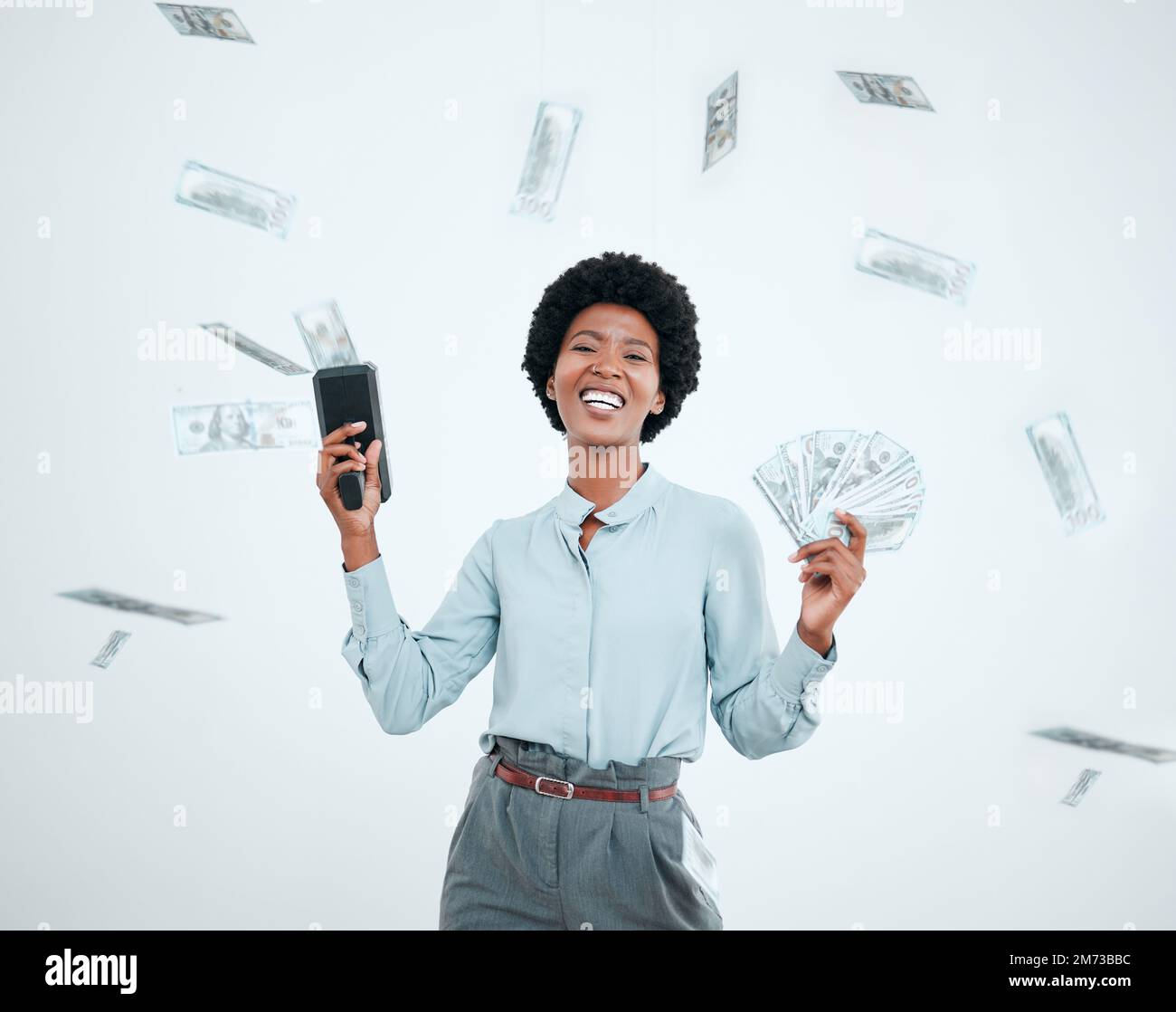 Cash cannon, money rain and wealth with a black woman winner in studio on a gray background. Portrait, winning or finance with a female employee Stock Photo