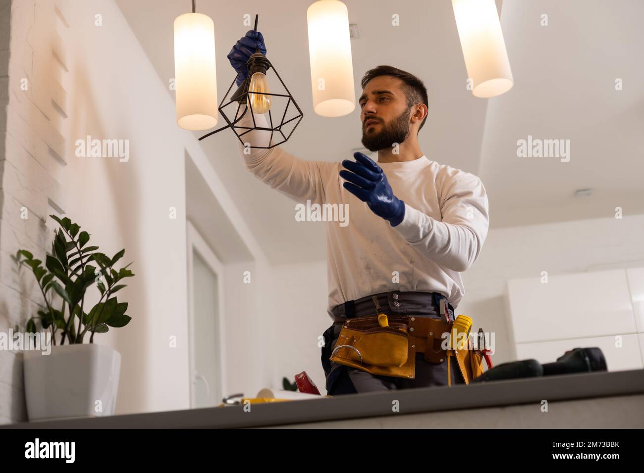 electrician installing led light bulbs in ceiling lamp Stock Photo