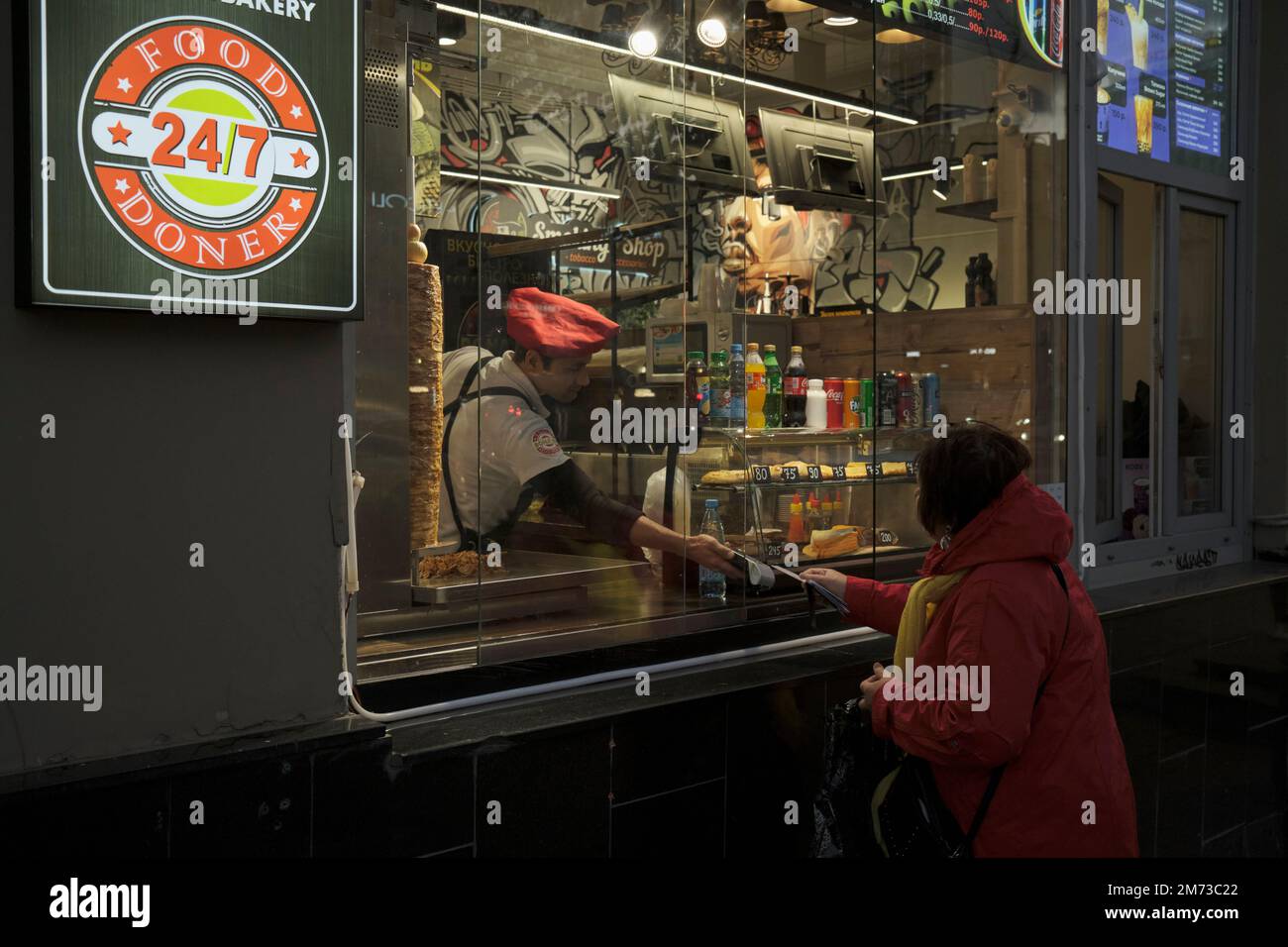 Woman pays for her order at a fast food stall. Moscow, Russia. Stock Photo