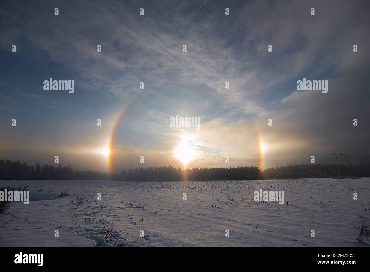 Sunset in the winter and natural atmospheric phenomenon Halo, parhelion, parhelia, sundog in Latvia Stock Photo
