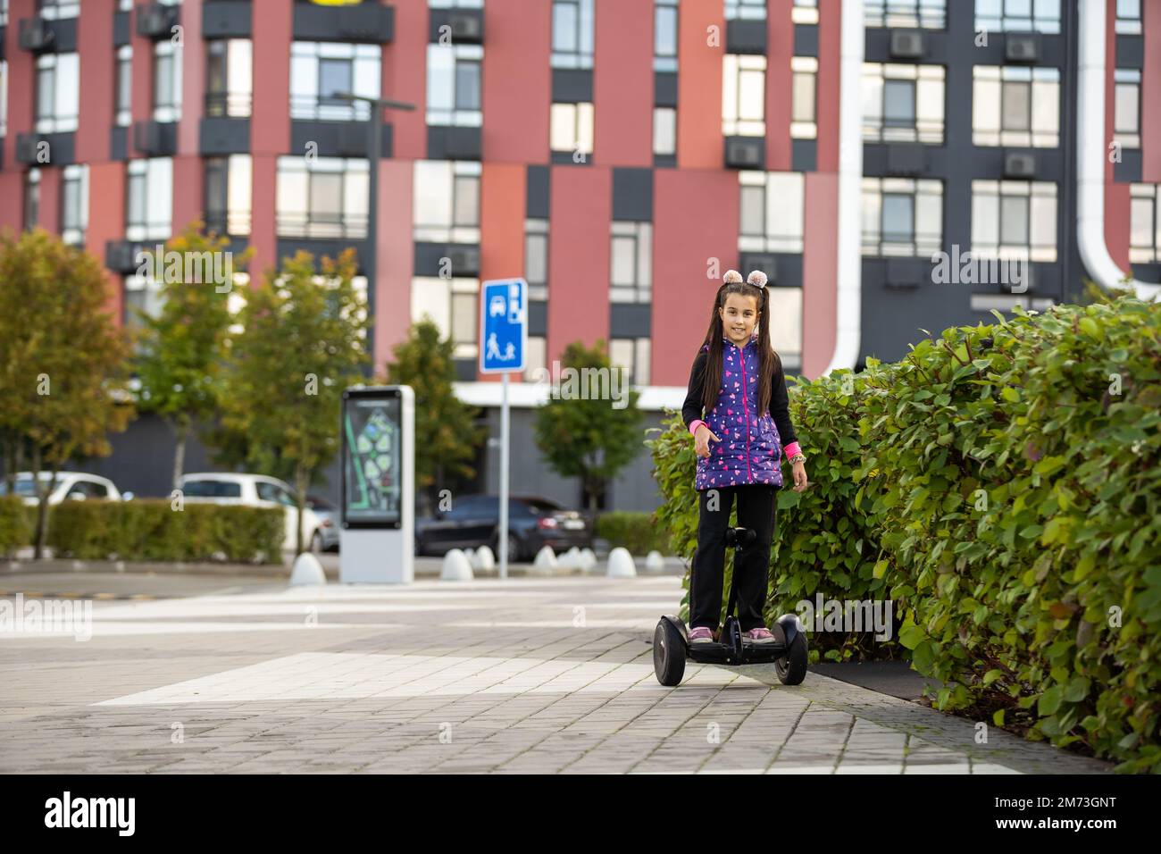 A little girl riding a electric scooter. Personal eco transport, gyro scooter, smart balance wheel. Popular electric transport Stock Photo