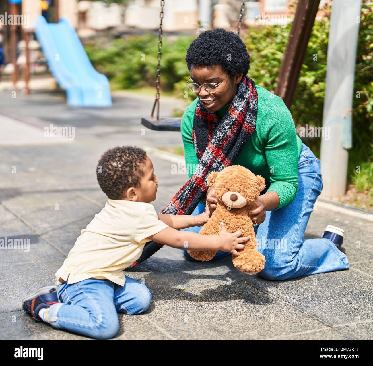 Mother and son playing with teddy bear at playground Stock Photo - Alamy