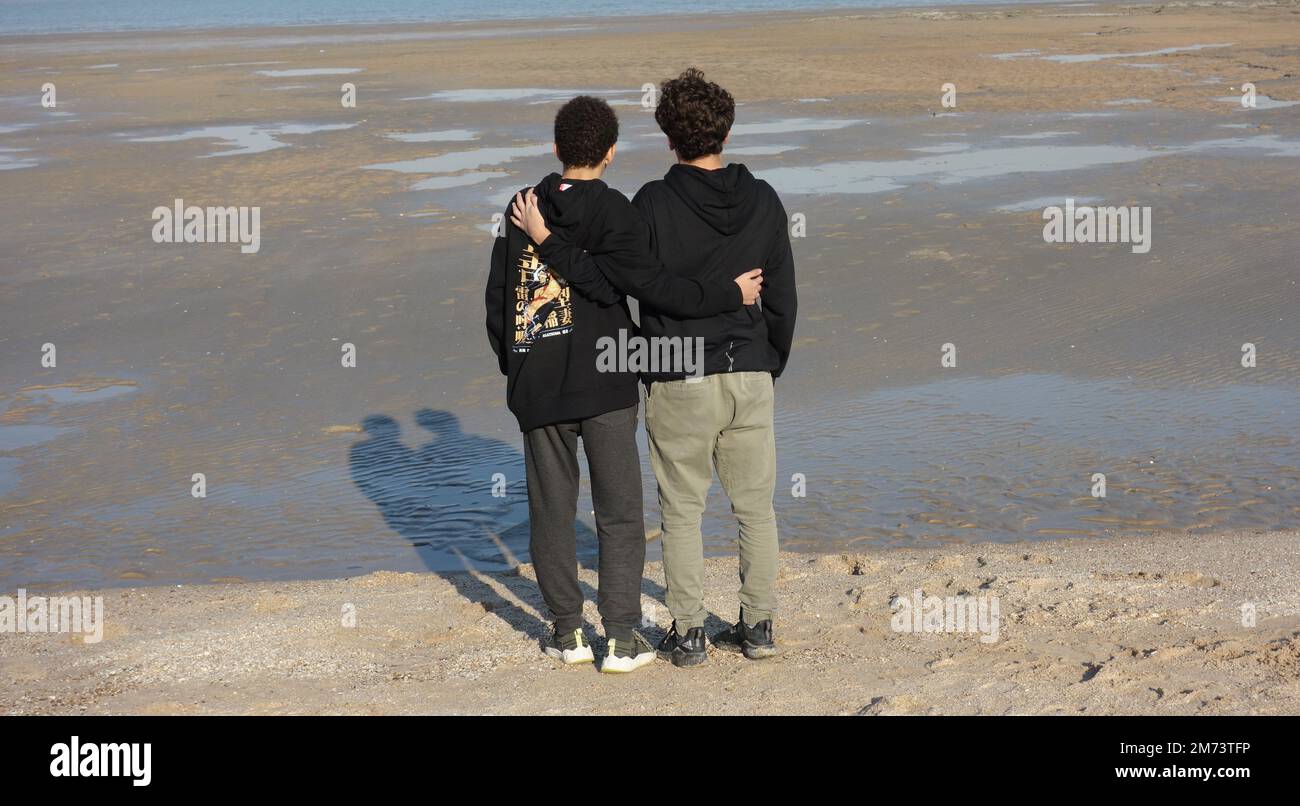 Brothers in the beach. Teenagers with Black clothes. Stock Photo