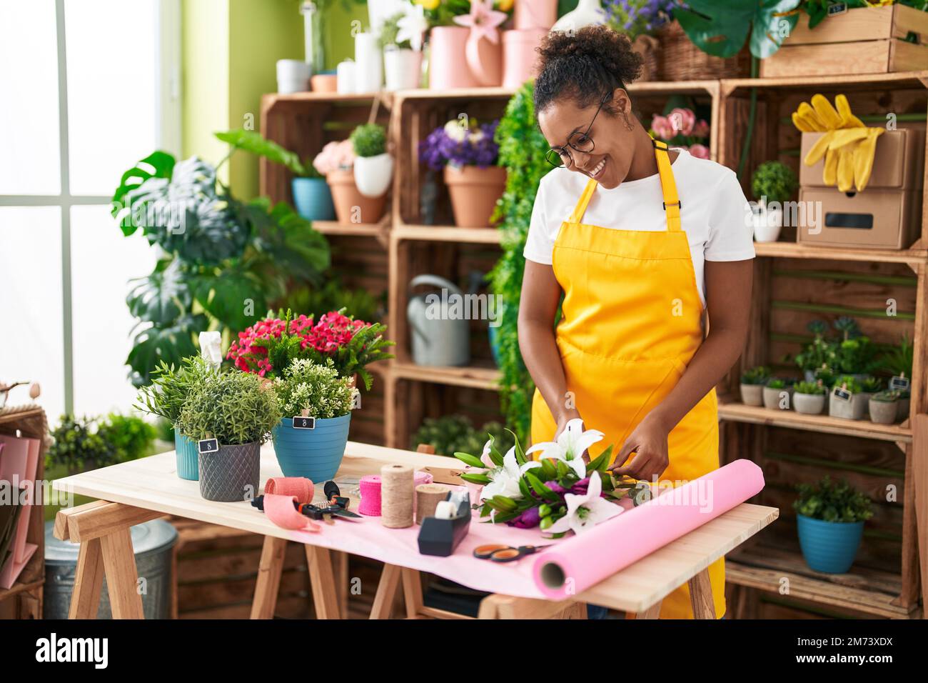 African american woman florist make bouquet of flowers at flower shop ...
