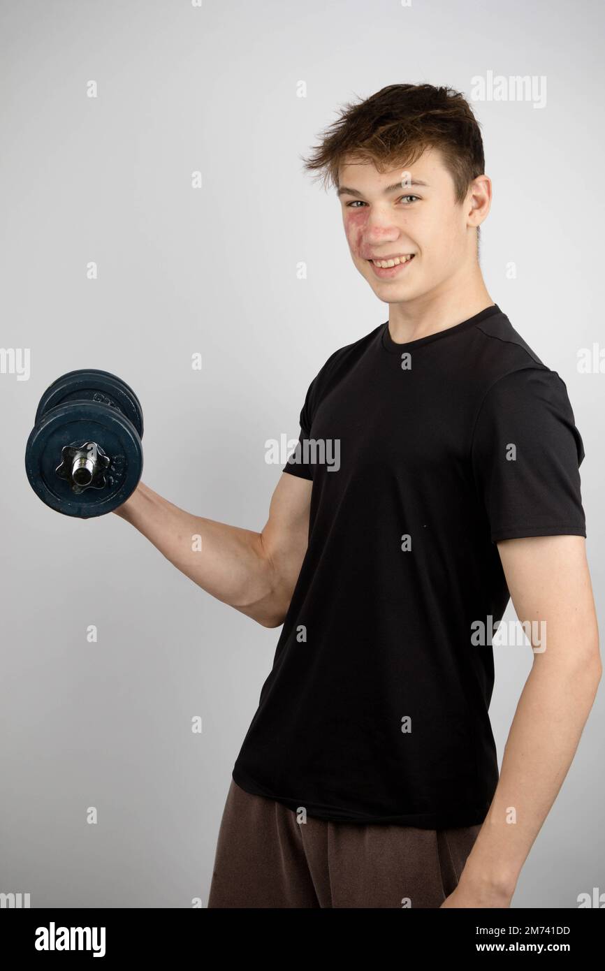 A Portrait of a 17 year old boy wearing a black tshirt using a dumbell Stock Photo Alamy