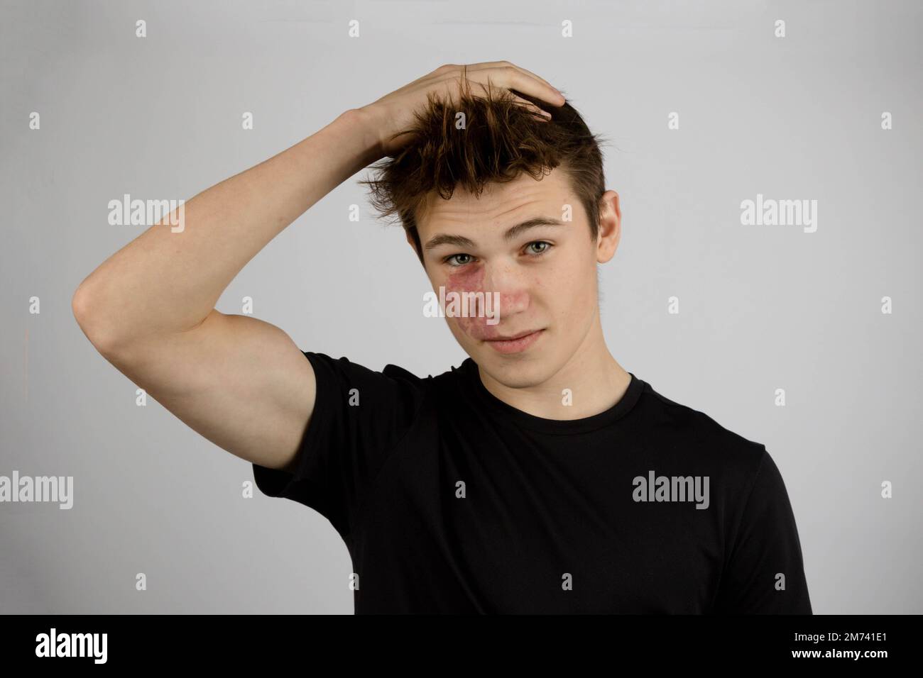 A Portrait of a 17 year old boy wearing a black tshirt playing with his hair Stock Photo Alamy