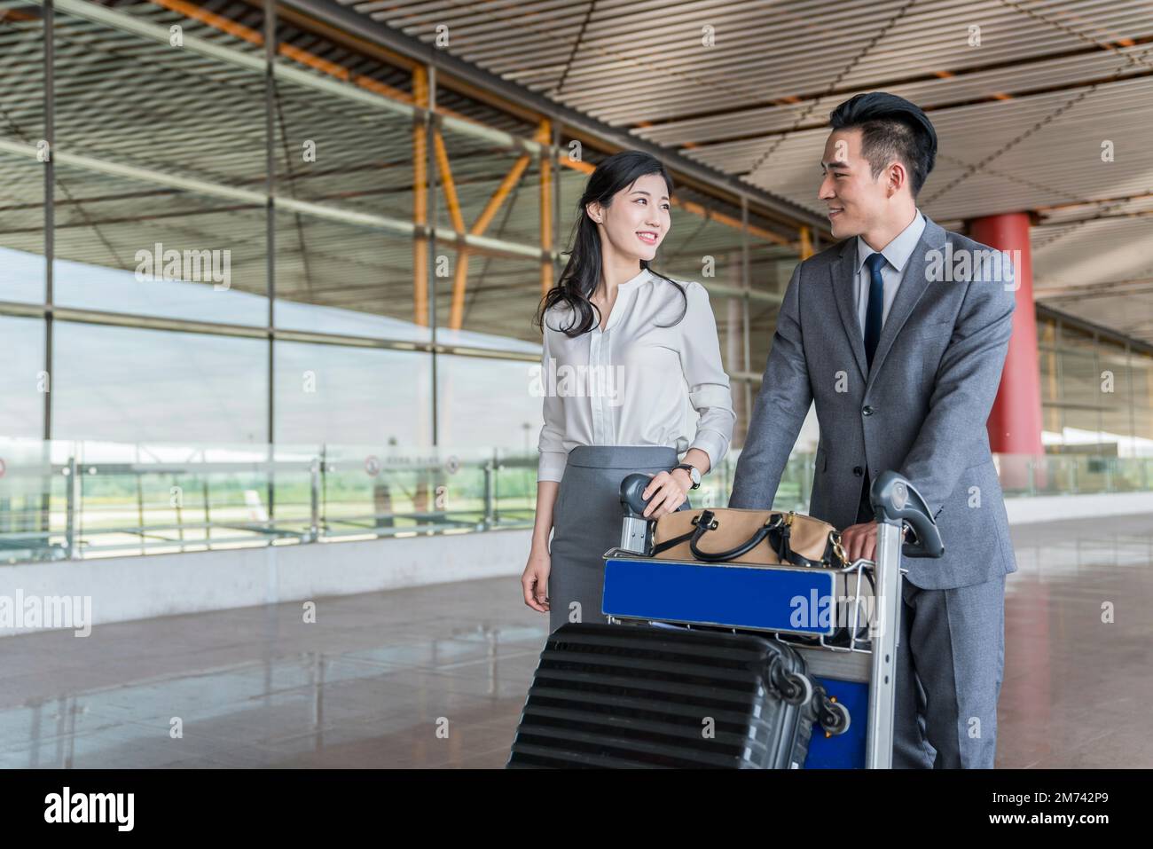 Business people pushing a suitcase at the airport Stock Photo Alamy