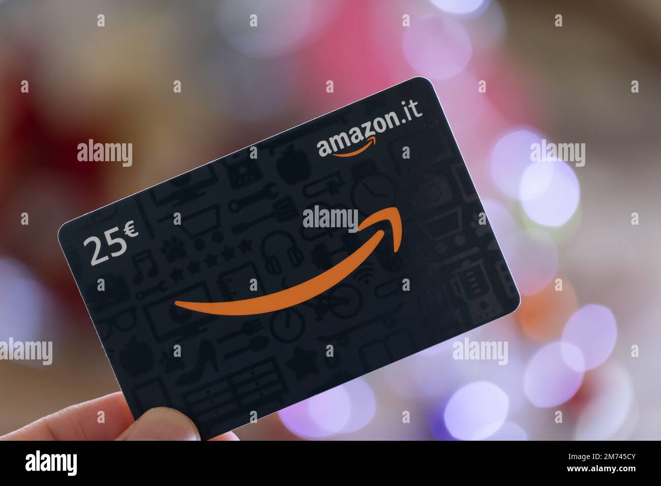 A hand holding an Amazon voucher (gift card Stock Photo Alamy