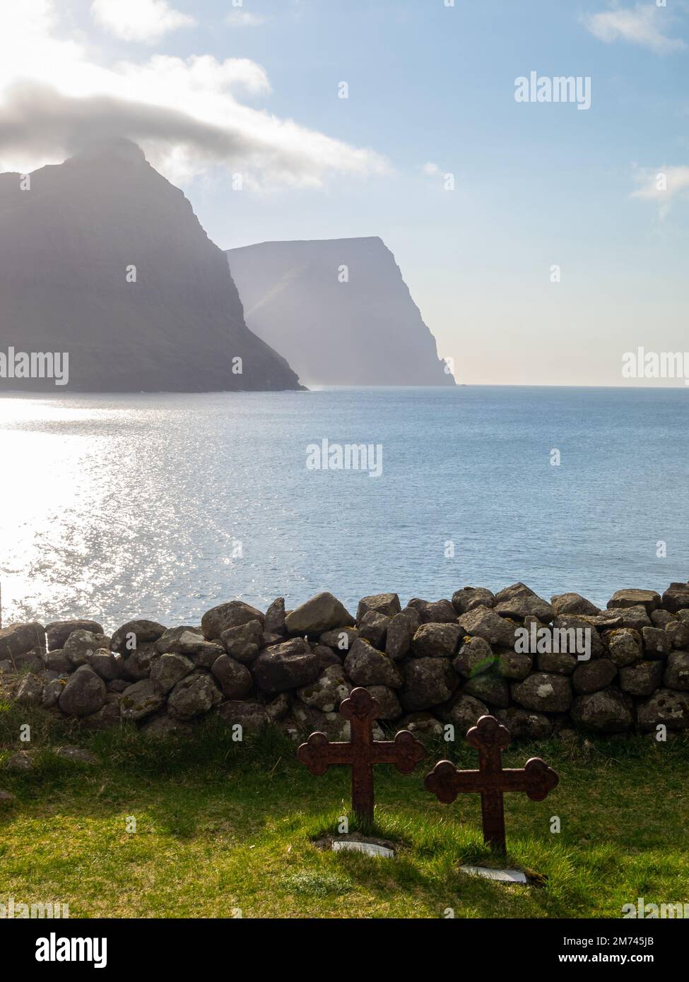 Burdoy and Kunoy silhouettes seen across the sea from Vidareidi graveyard Stock Photo