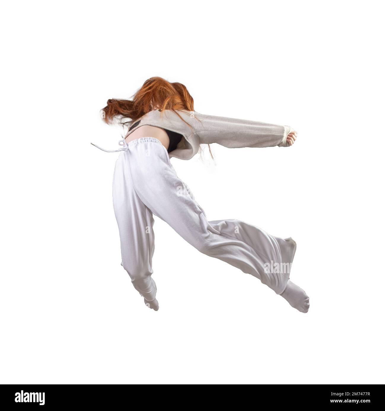 Side view of teen age girl in zero gravity or a fall. Ggirl is flying, Falling or floating in the air. Girl weared in white clothes. Isolated over whi Stock Photo