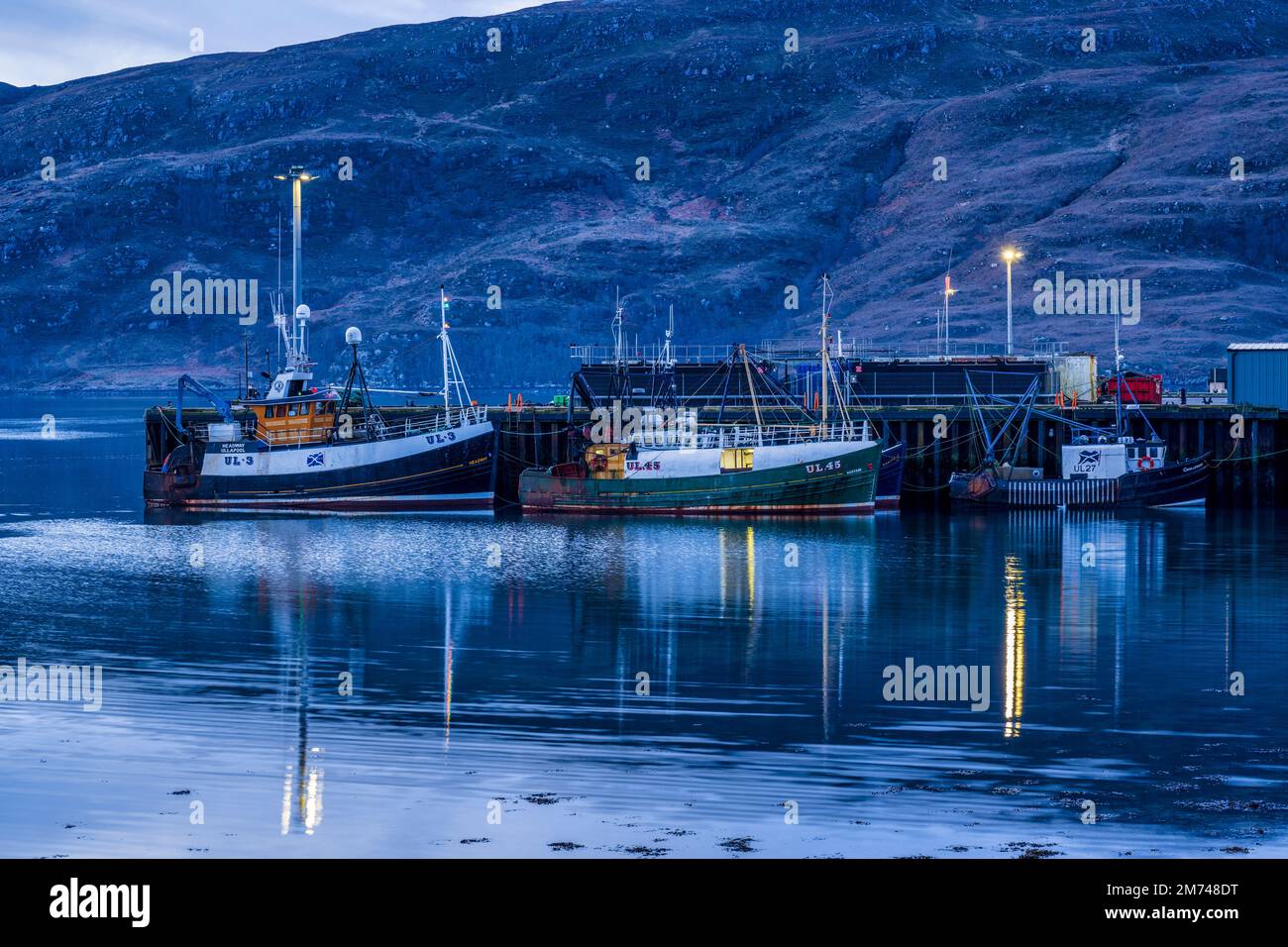 Fishing boats moored in Ullapool harbour at daybreak - Ullapool, Wester Ross, Highland, Scotland, UK Stock Photo