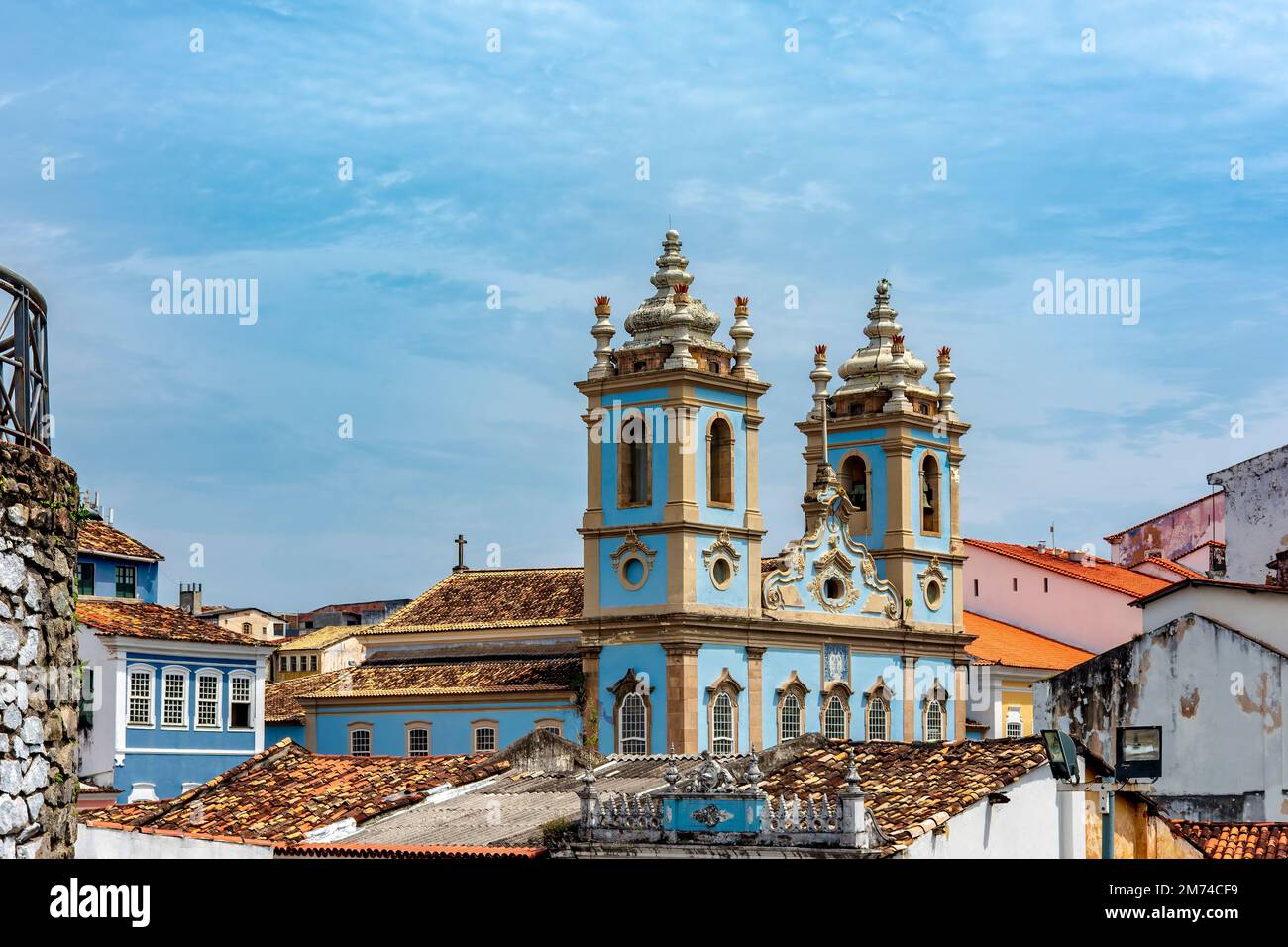 Tower and facade of a historic baroque church emerging from among the houses and roofs of the Pelourinho district, city of Salvador, Bahia Stock Photo