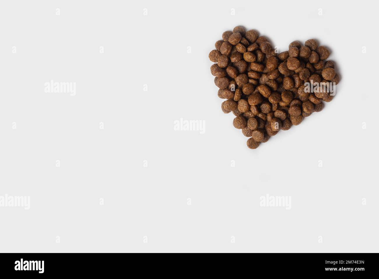 Dry pet food in the shape of a heart isolated on a white background