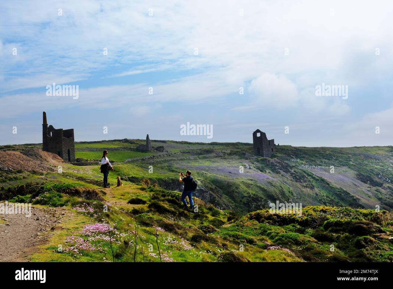 Tourists enjoying the abandoned tin mines at Botallack, a World Heritage Site, Cornwall, UK - John Gollop Stock Photo