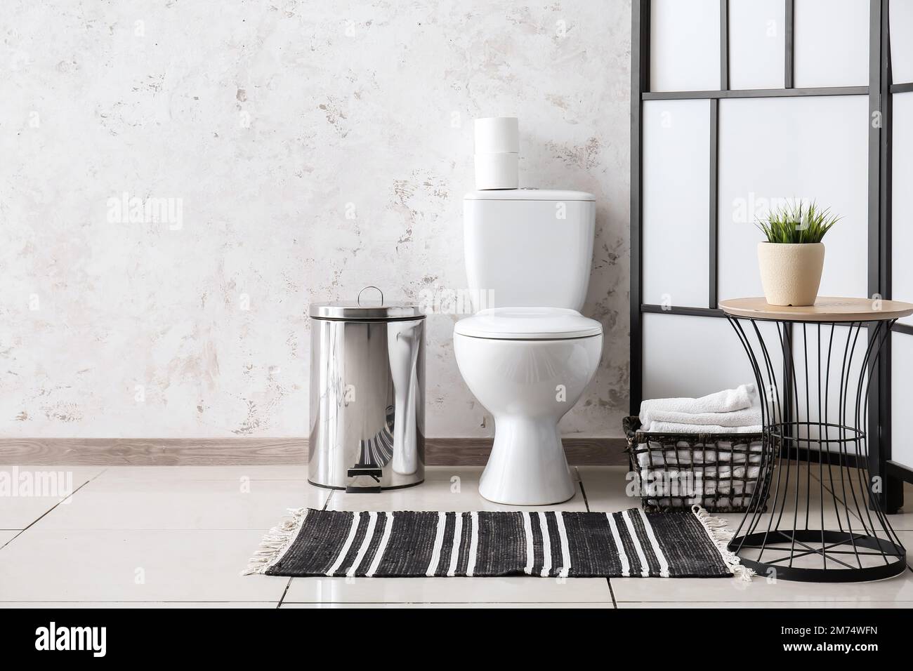 Interior of restroom with toilet bowl, table and folding screen Stock ...