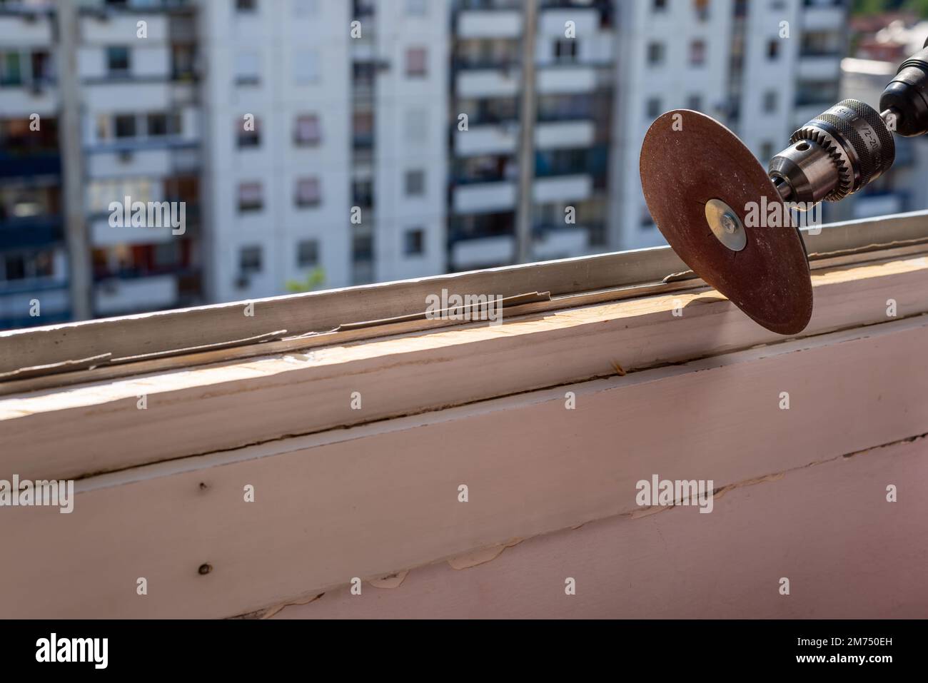 Sanding an old window frame during renovation work with an apartment