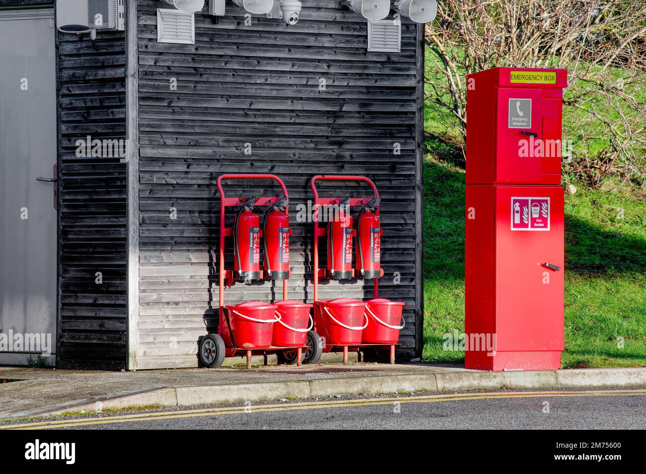 Powder fire extinguisher and red fire buckets for emergency use Stock Photo