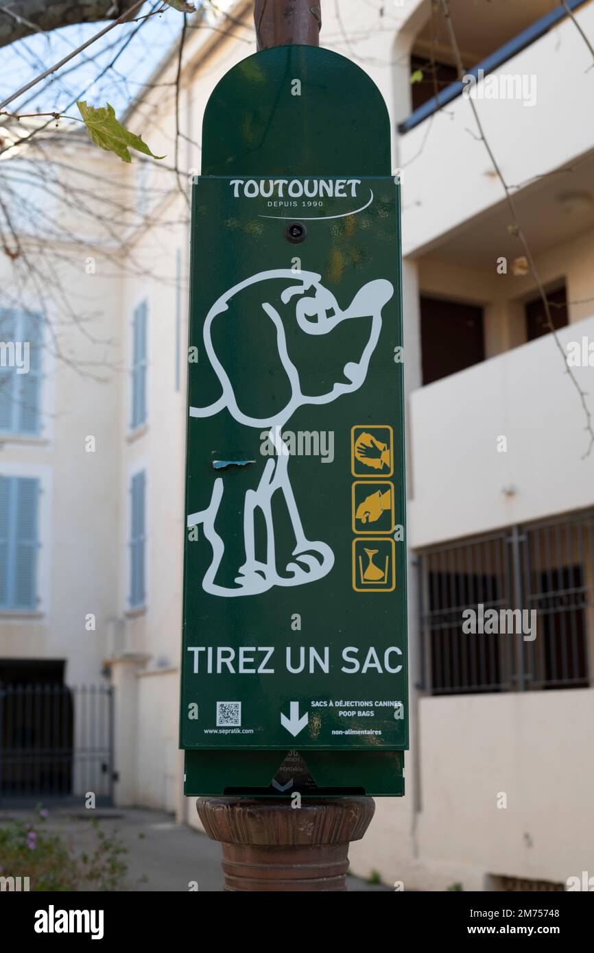 Dog Bag Dispenser fix on a post in South of France, with text and description in French Stock Photo