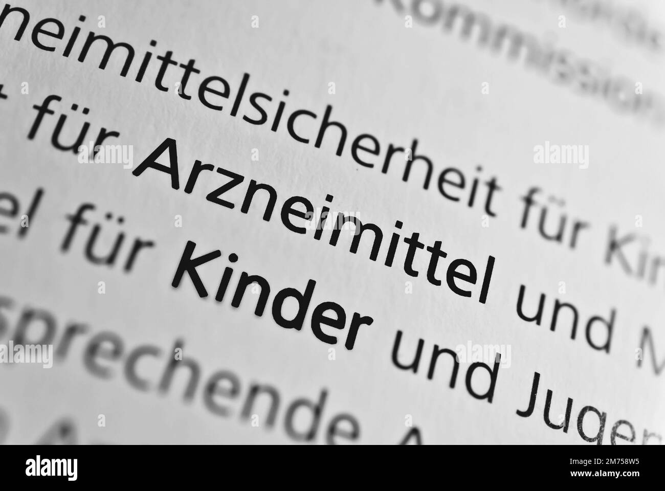 A closeup of the german word Kinder written in bold font surrounded by blurred wordsTranslation- children Stock Photo