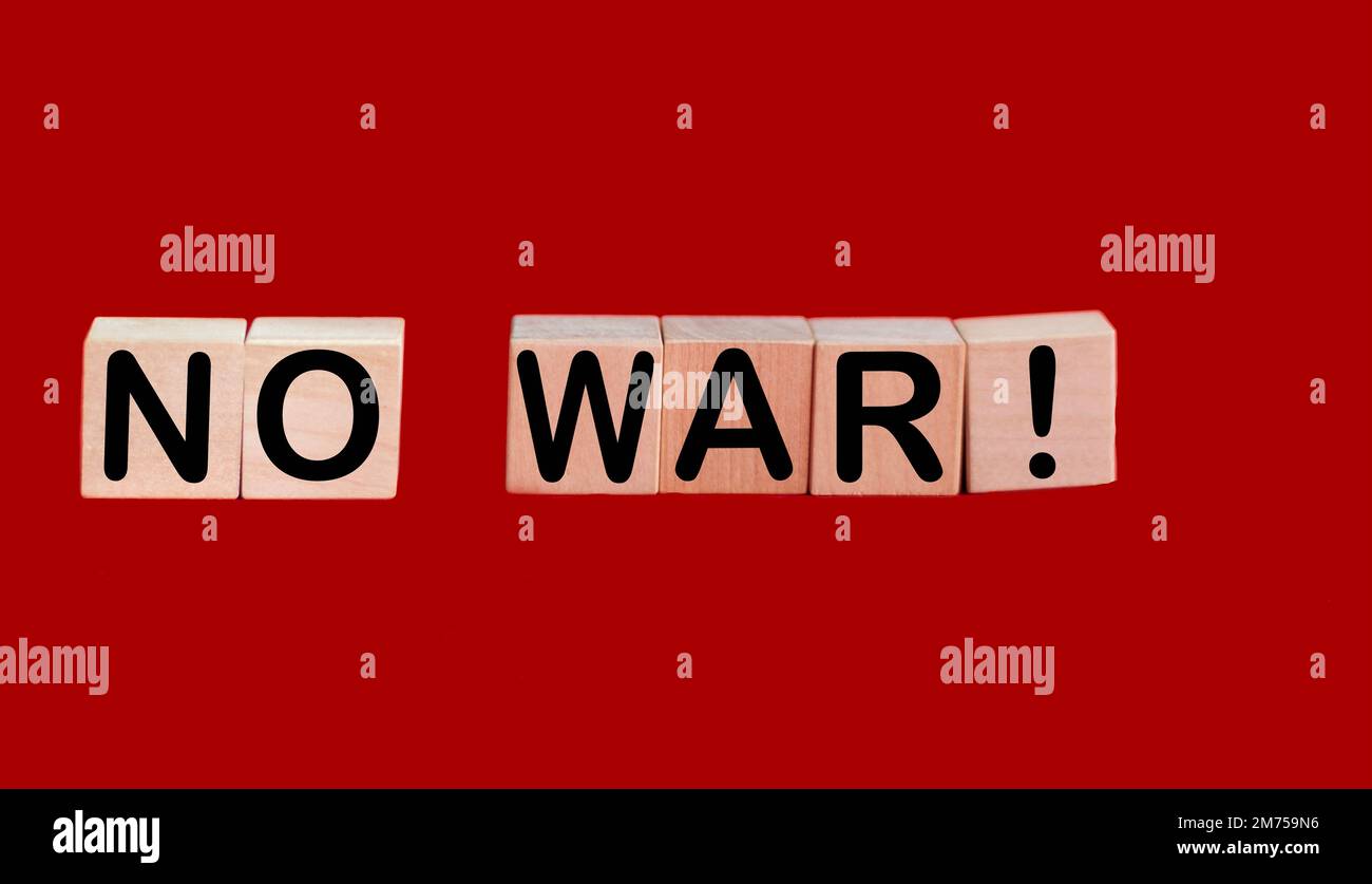 On a bright red background, wooden cubes with the inscription NO WAR. Stock Photo
