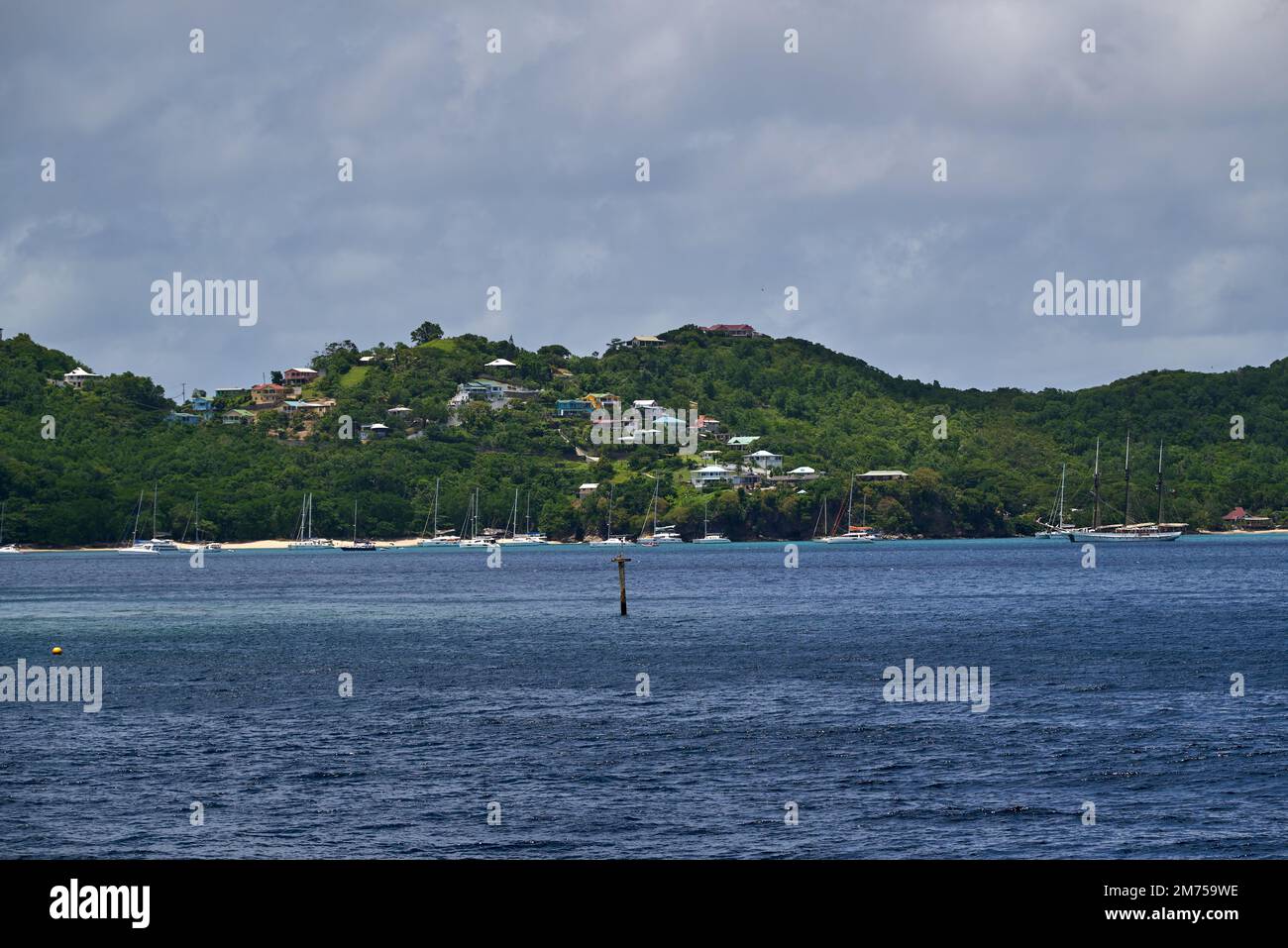A landscape view of the sea with houses in the green hills on the beach ...