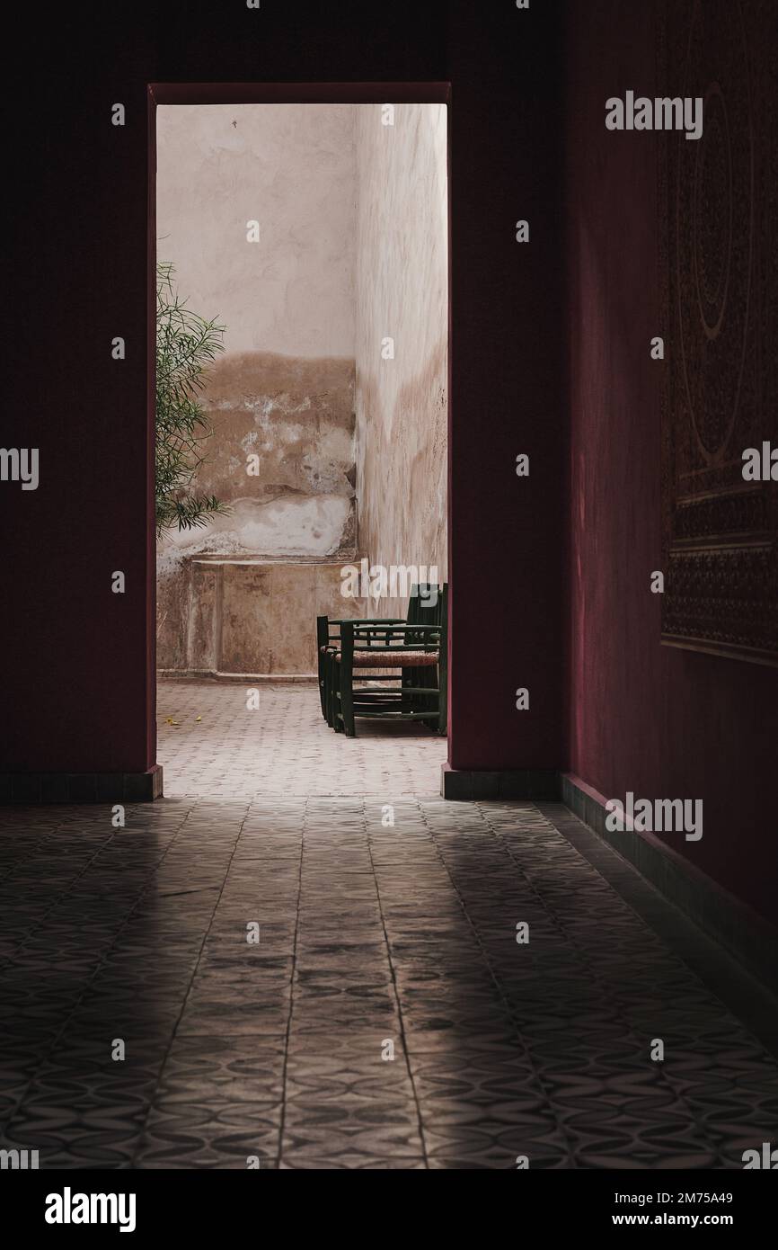 View through dark hallway to outside garden patio. Portrait orientation ...