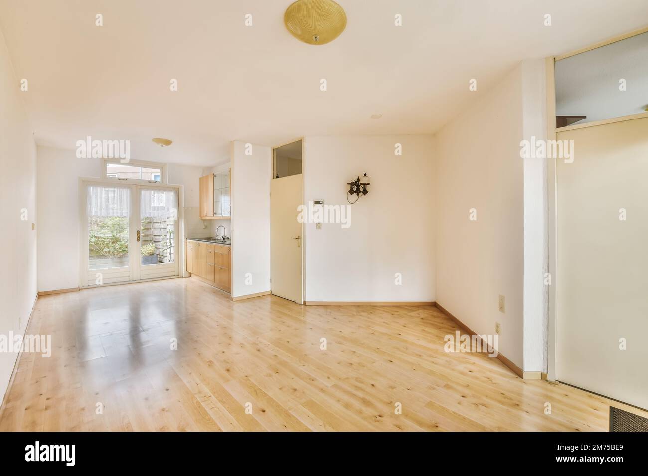 an empty living room with wood flooring and white walls in the room is very clean, but there is no furniture Stock Photo