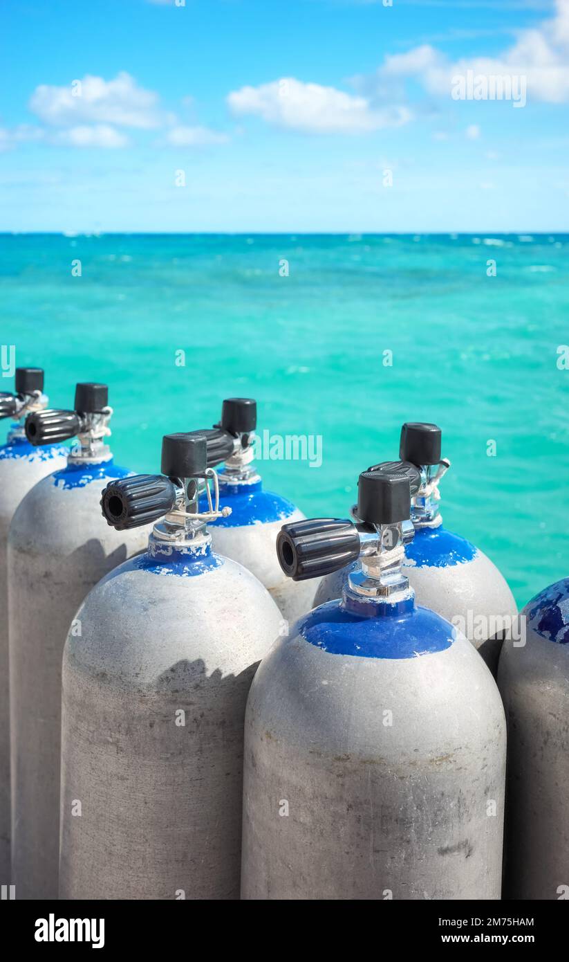 Close up picture of scuba tanks with turquoise water in the background, selective focus. Stock Photo