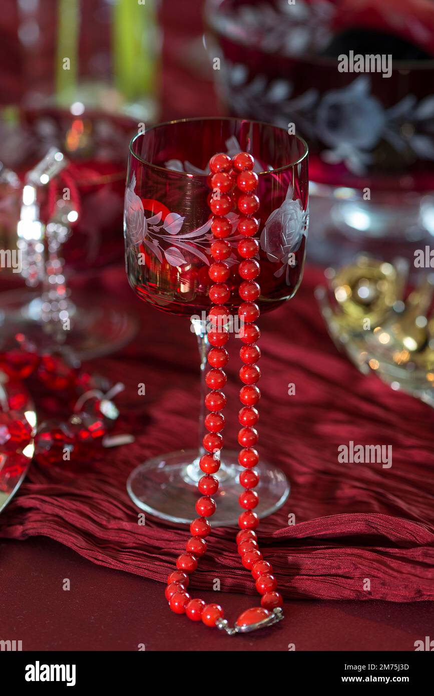 Red pearl necklace decorated on a wine glass, Bavaria, Germany Stock Photo