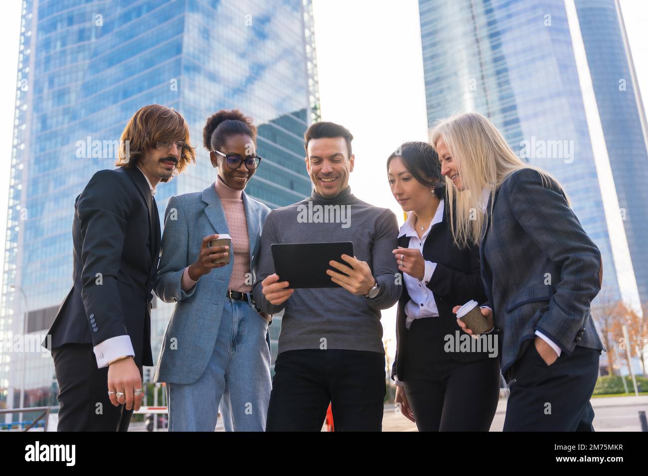 A group of multi-ethnic business people in a business park looking at a tablet Stock Photo
