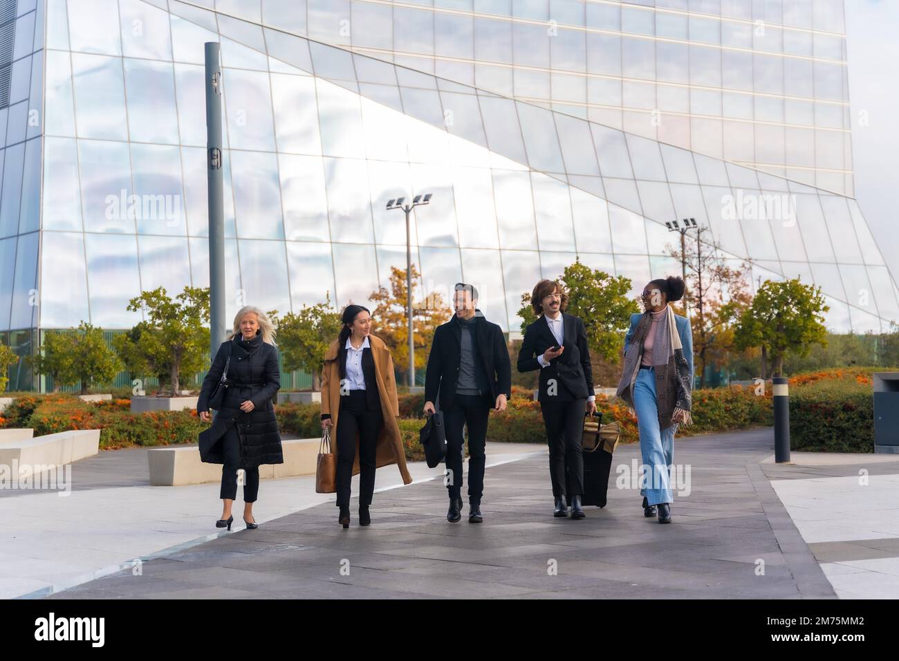 Group of multi-ethnic business people with suitcases in a business park walking to work Stock Photo