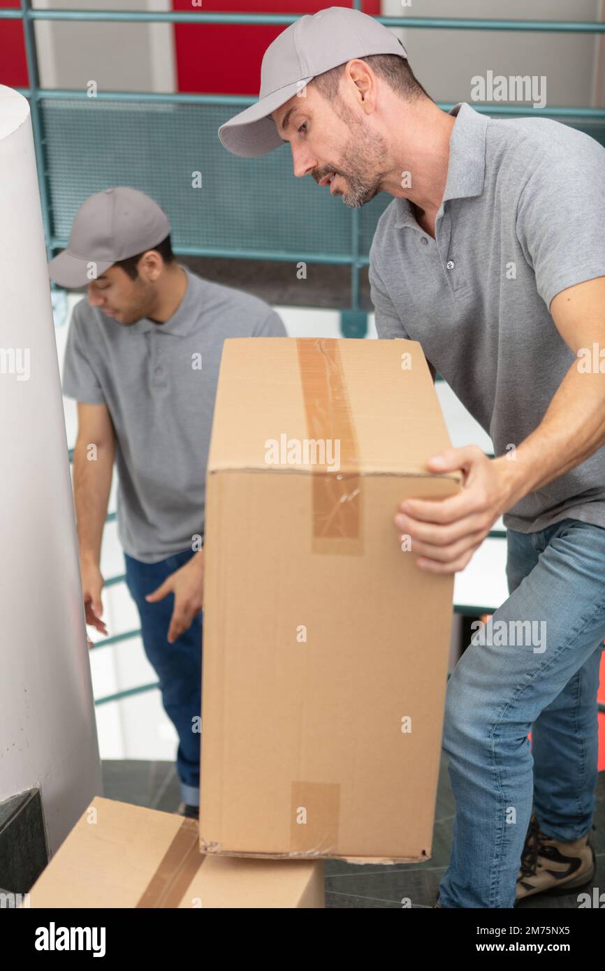 male movers carrying boxes up stairs in new house Stock Photo Alamy