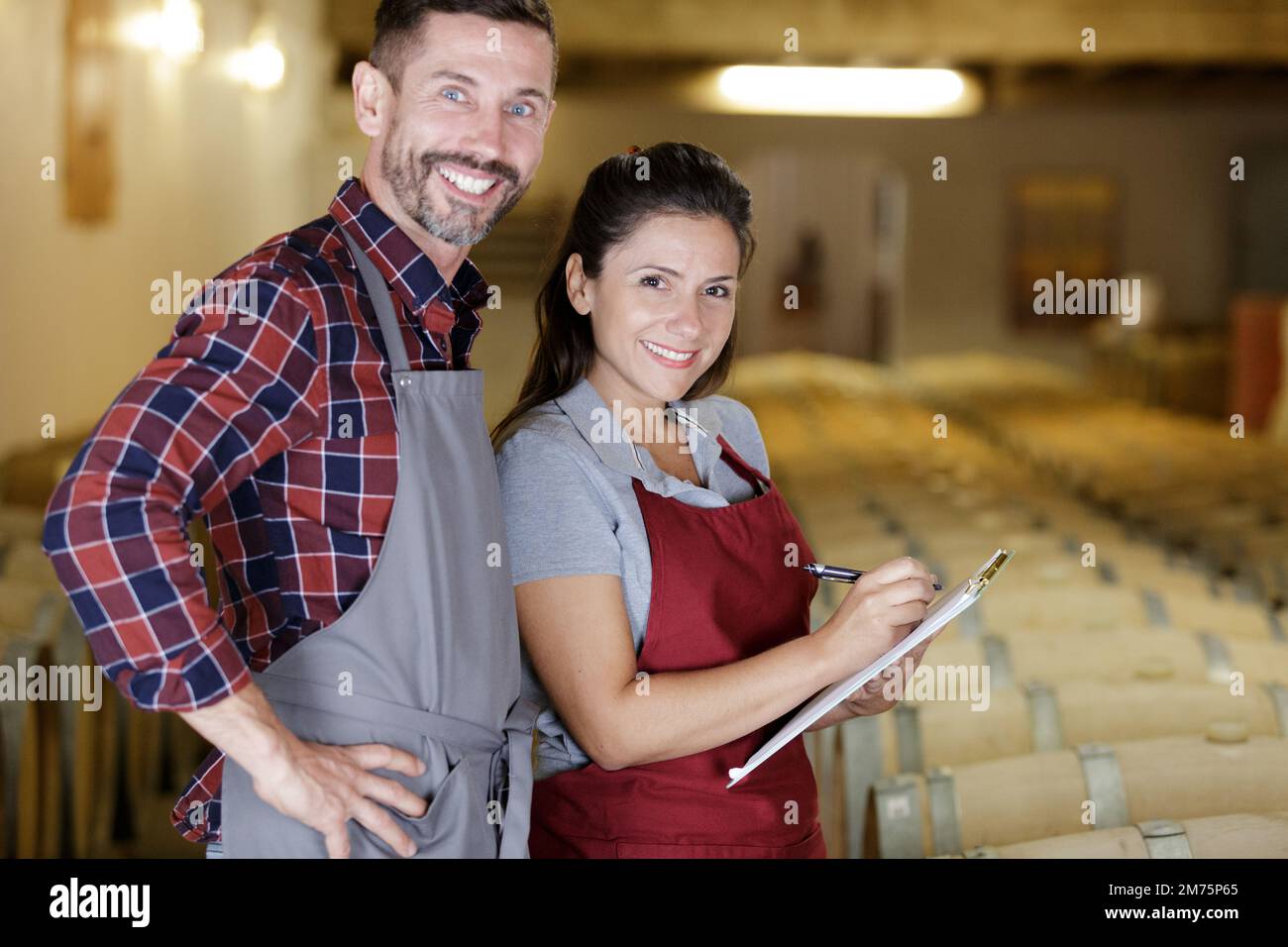 two wine technicians working with wine in cellar Stock Photo Alamy