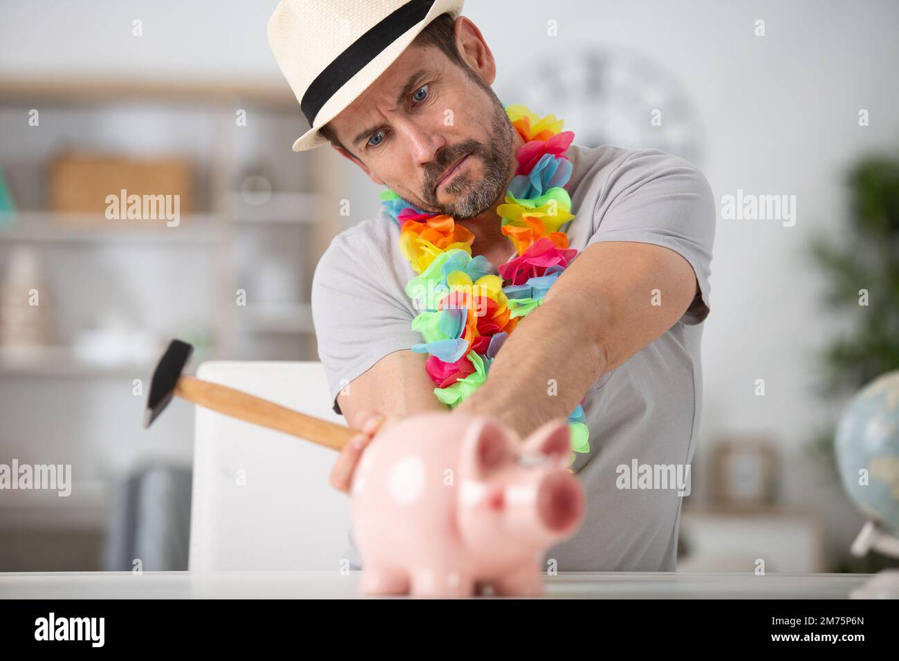 serious man breaking piggy bank with hammer Stock Photo - Alamy