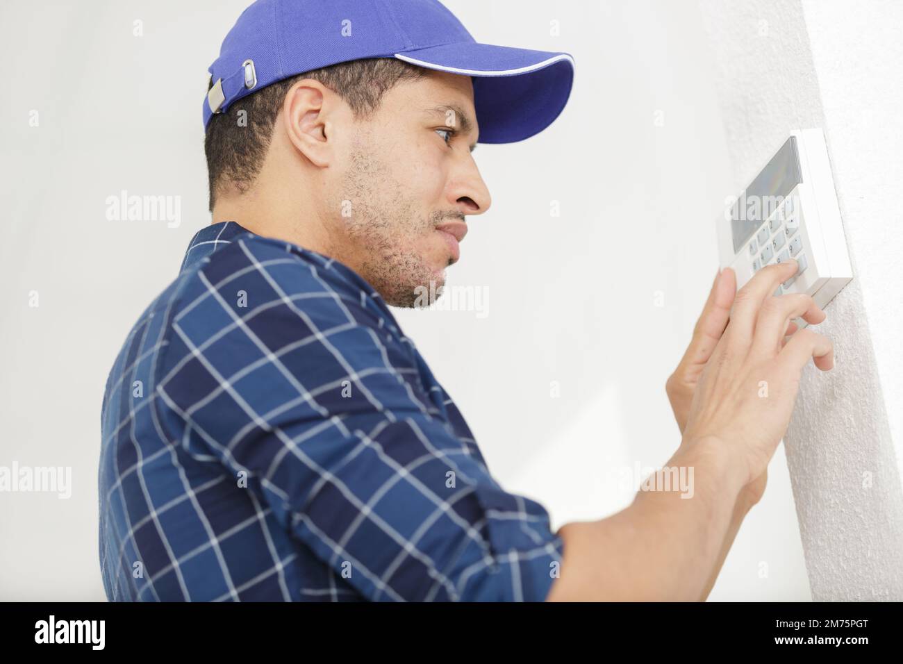 workman setting up the alarm with keyboard Stock Photo