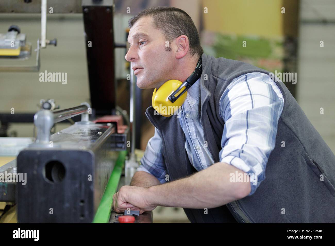 man assembles electronic components on a machine in a factory Stock Photo