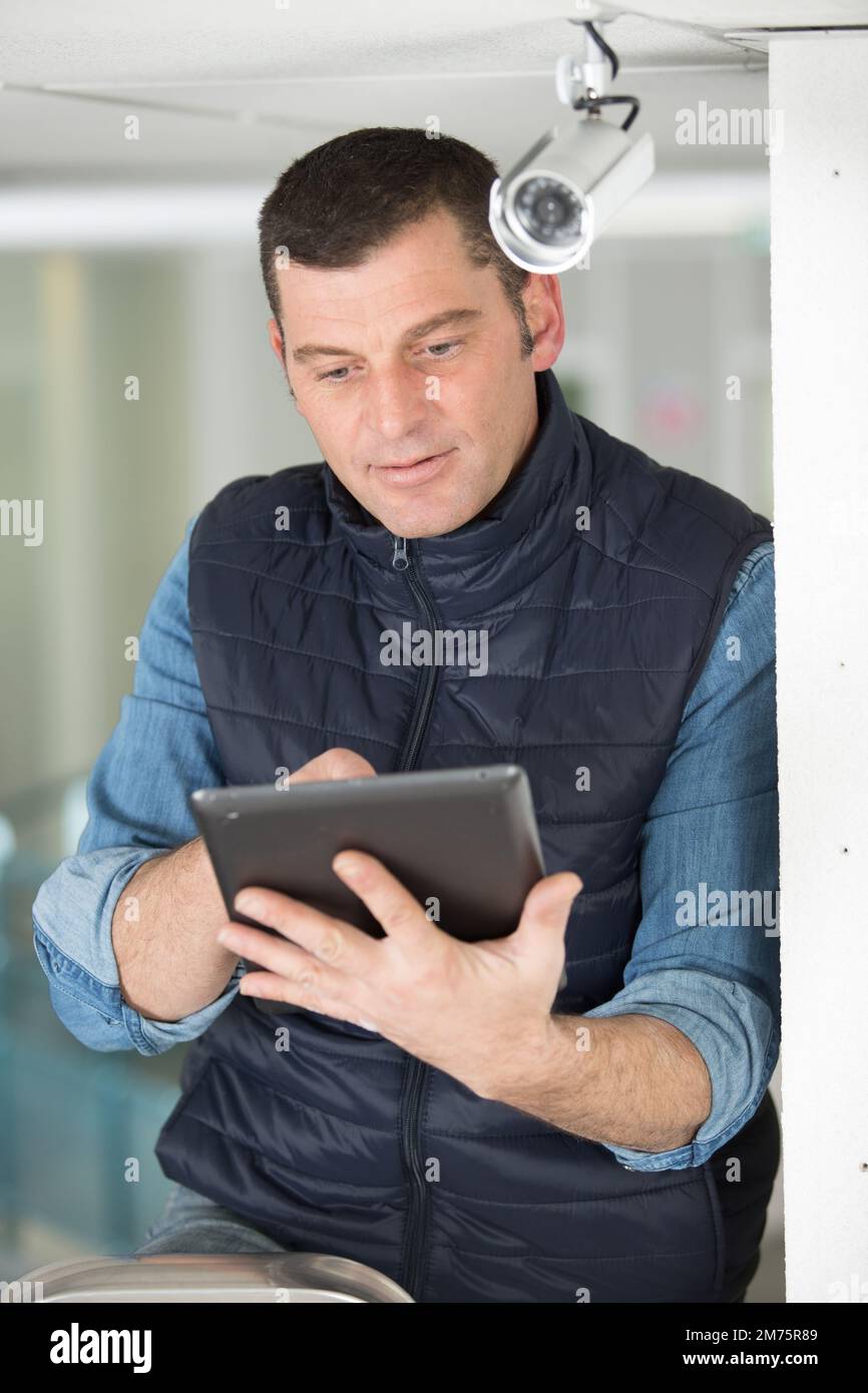 maintenance man by cctv camera holding tablet Stock Photo Alamy
