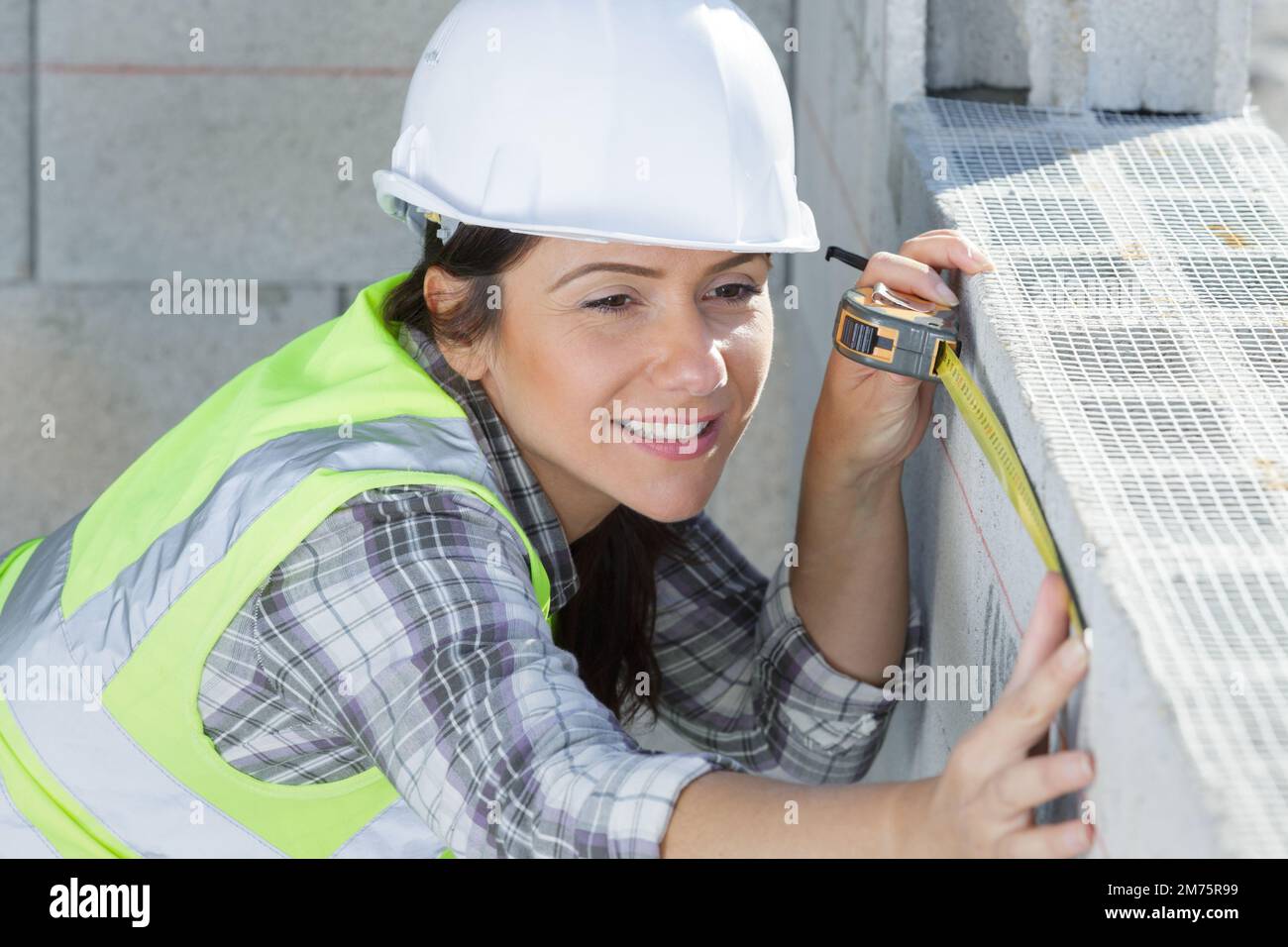 builder worker woman measuring a cement block Stock Photo Alamy