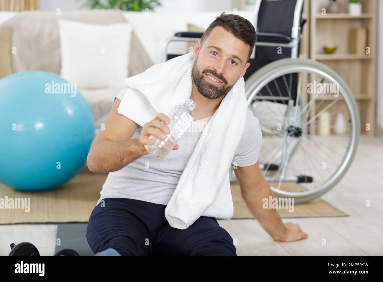 man with bottle of water dumbbell and green towel Stock Photo - Alamy