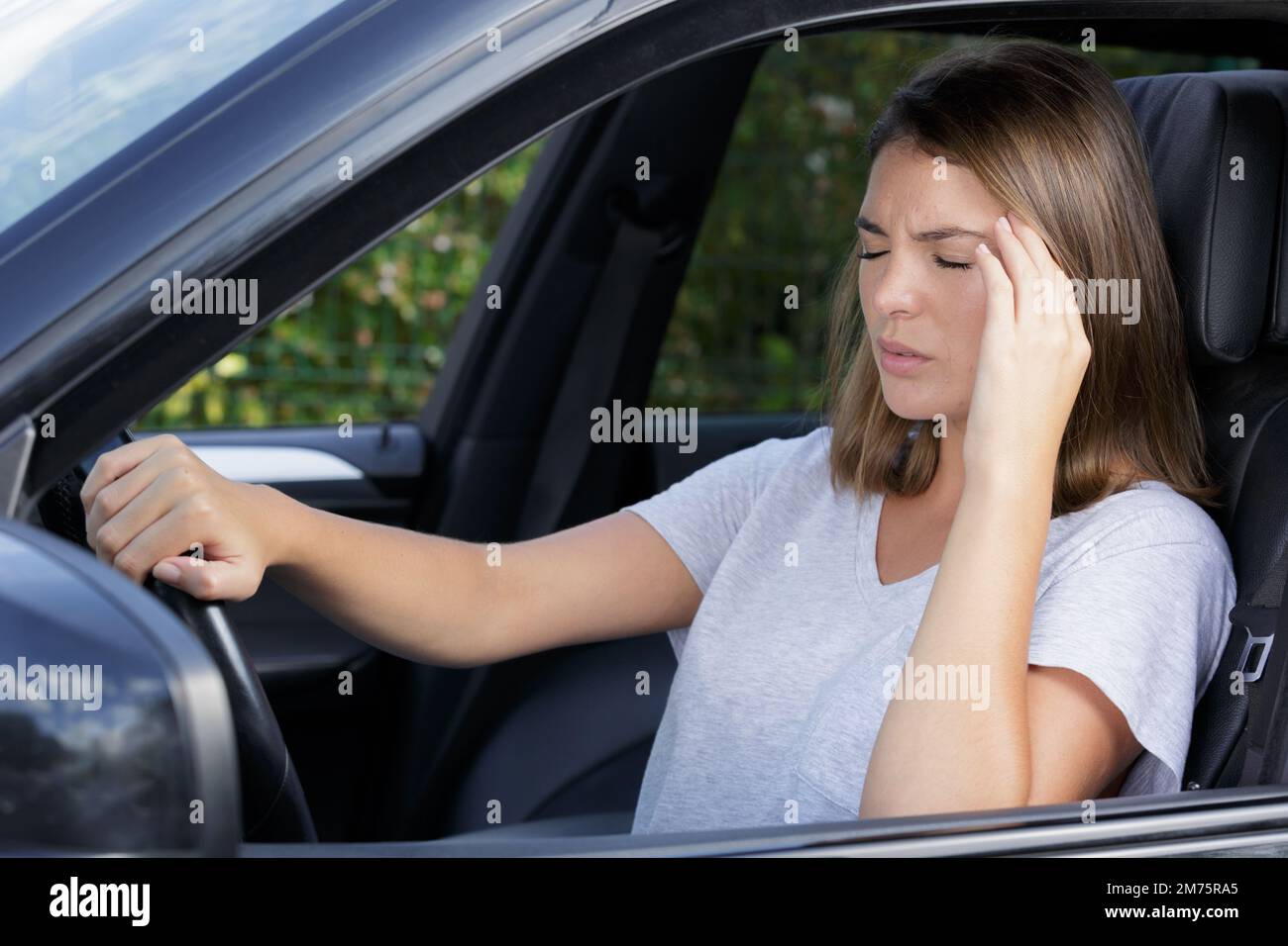 woman with headache driving a car Stock Photo Alamy