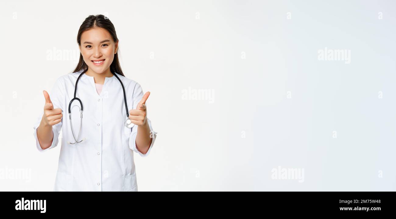 Beautiful female asian doctor, nurse in uniform showing thumbs up and ...