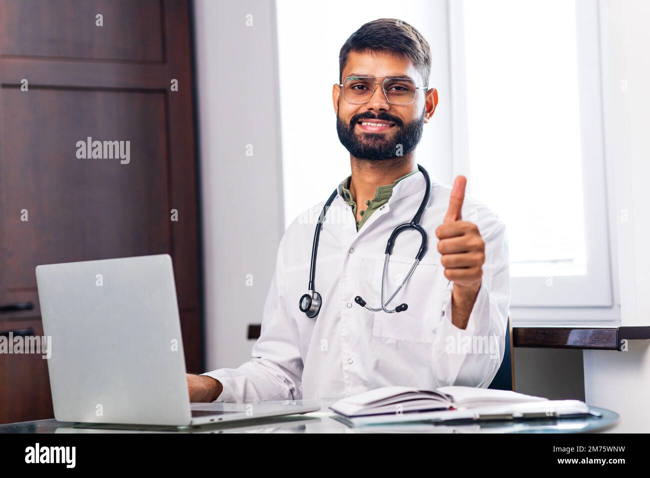 hispanic medical student in white coat with stethoscope in clinic Stock Photo