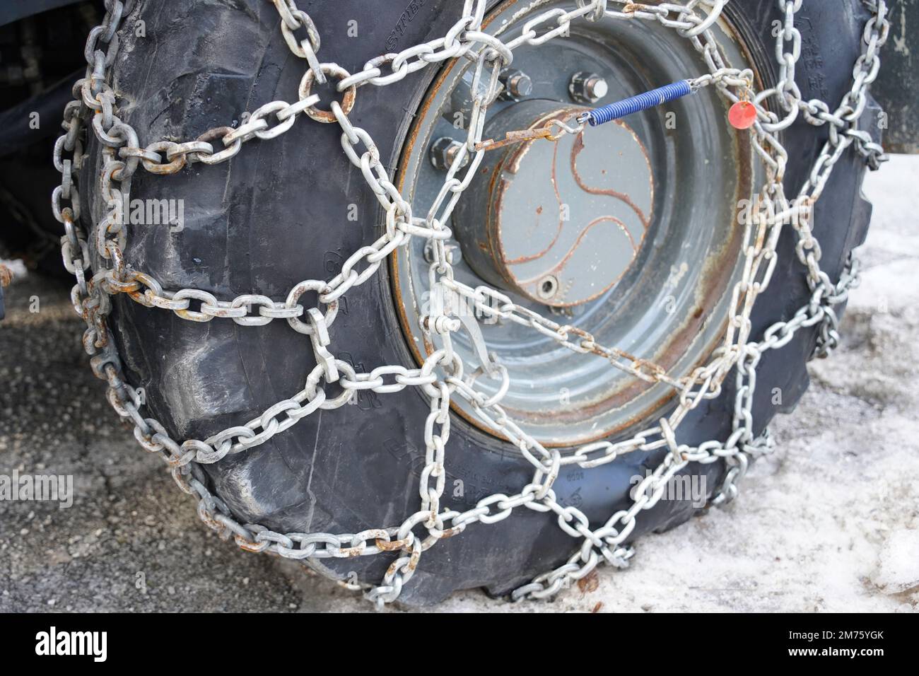 Seefeld, Austria - December 2022: Close up detail of large commercial vehicle equipped with snow chain, helps with tyre traction Stock Photo