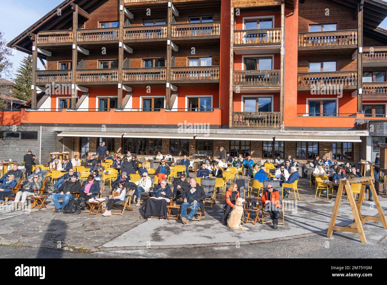 Seefeld, Austria - December 2022: Locals and tourists sunbathing and enjoying the view at an apres ski restaurant, hotel in the Austrian Alps Stock Photo