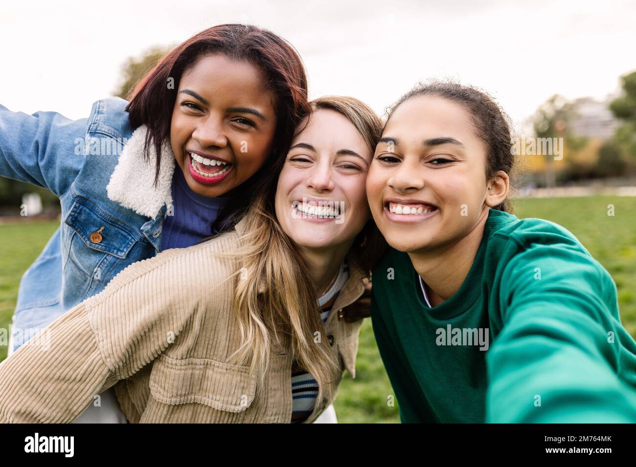 Multi-ethnic group of three young women taking a selfie having fun outdoor Stock Photo