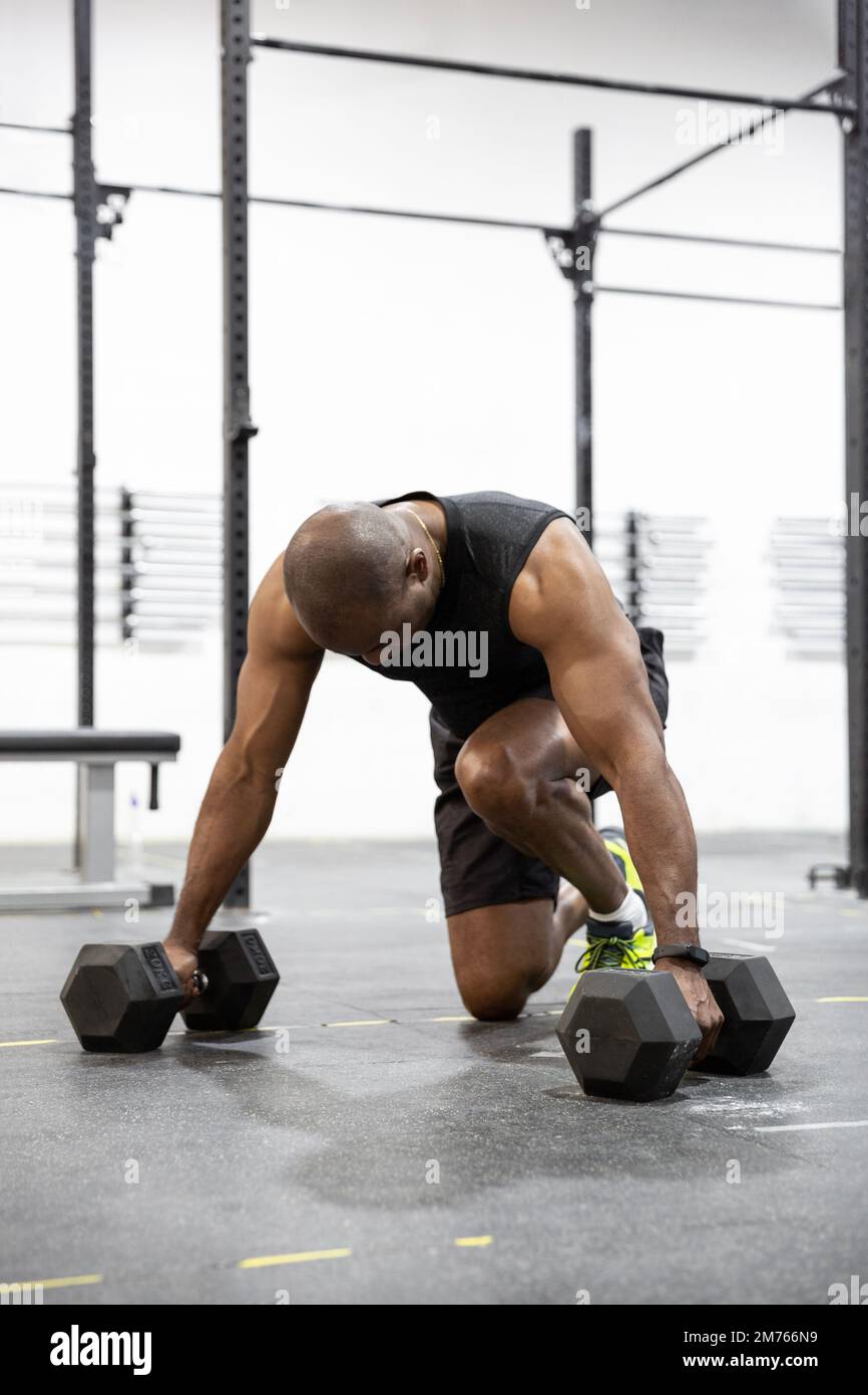African American adult male doing intense exercise at the gym. Space ...