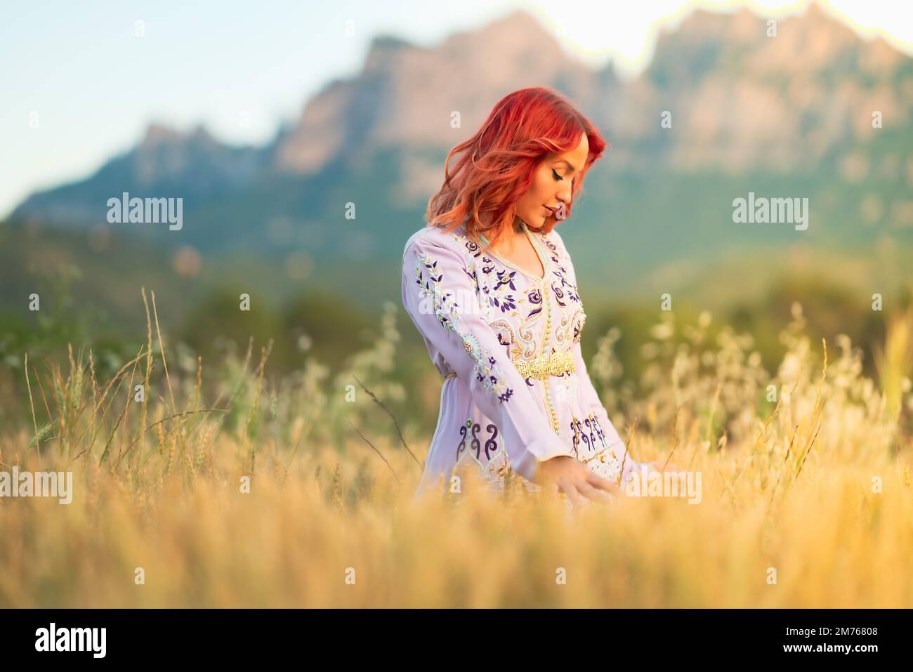A beautiful redhaired lady with an embroidered white dress and gold