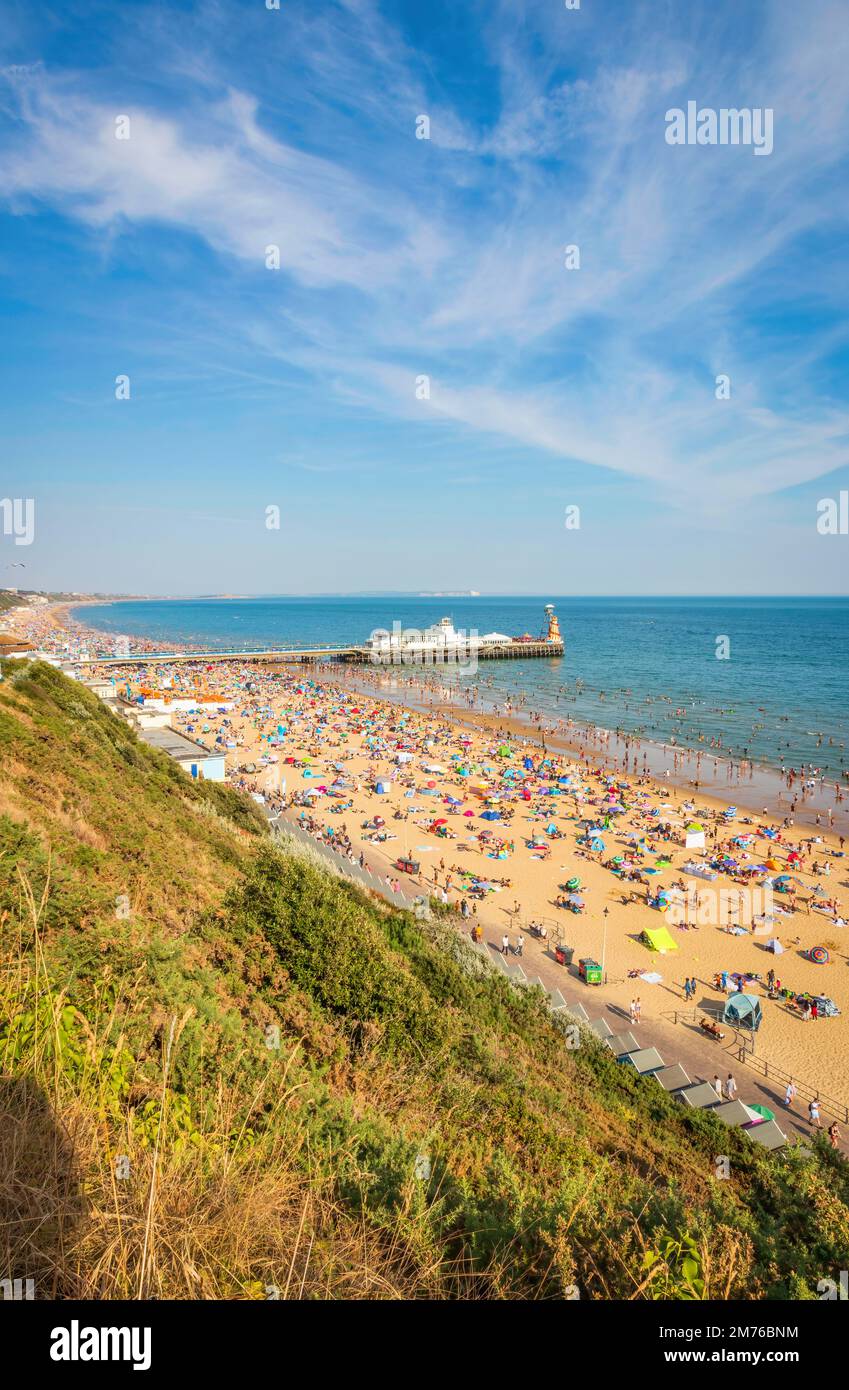 View of Bournemouth beach and Pier in Bournemouth Dorset UK during sunset. full beach during summer. people taking sunbathe. crowded beach Stock Photo