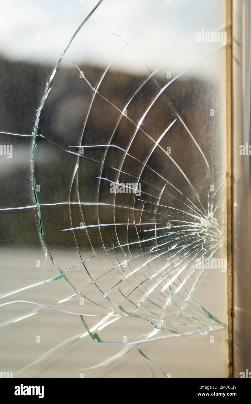 Dirty broken window glass with cracks from stone hit or beak from bird